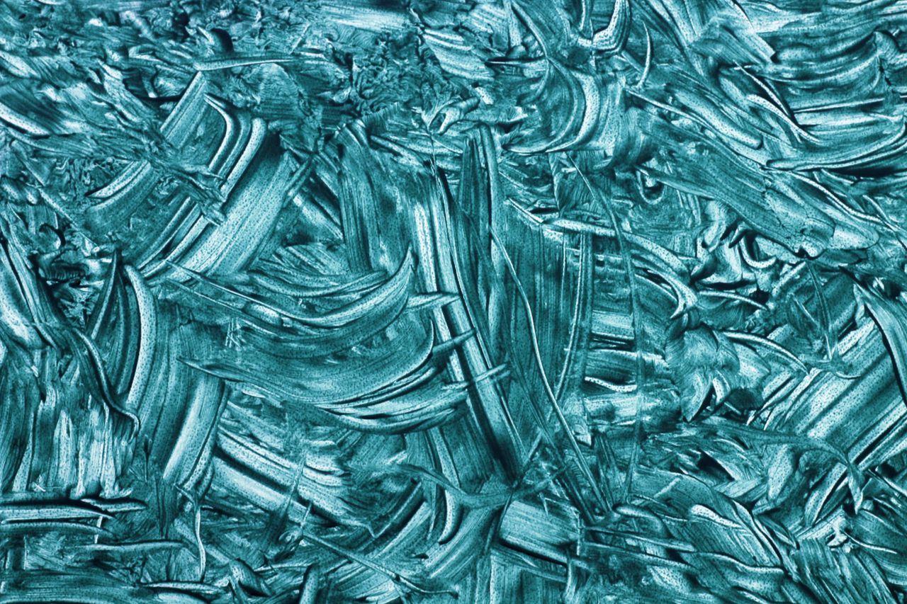 Vibrant teal abstract texture with dynamic brush strokes and artistic patterns.
